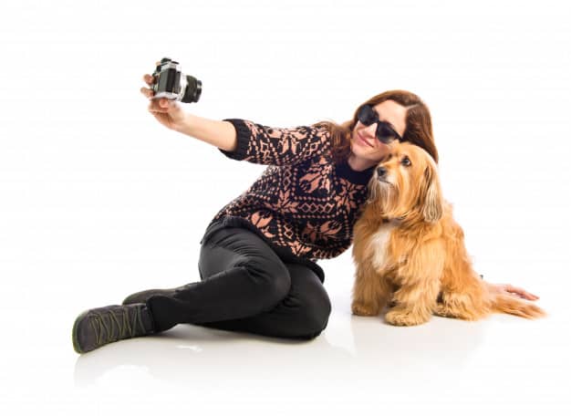 Mulher e um cachorro tirando foto em fundo branco